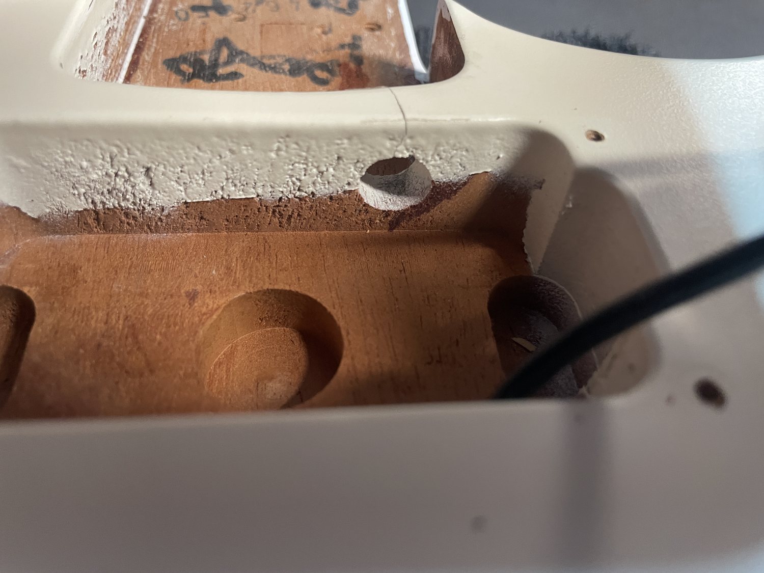 Neck pocket route and crack area inspected before maple plug repair